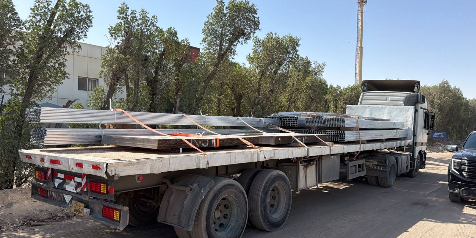 Galvanised steel pipes and sheets loaded on a trailer for delivery
